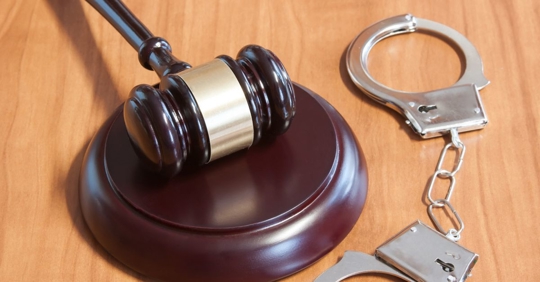 judicial hammer and handcuffs on a wooden table